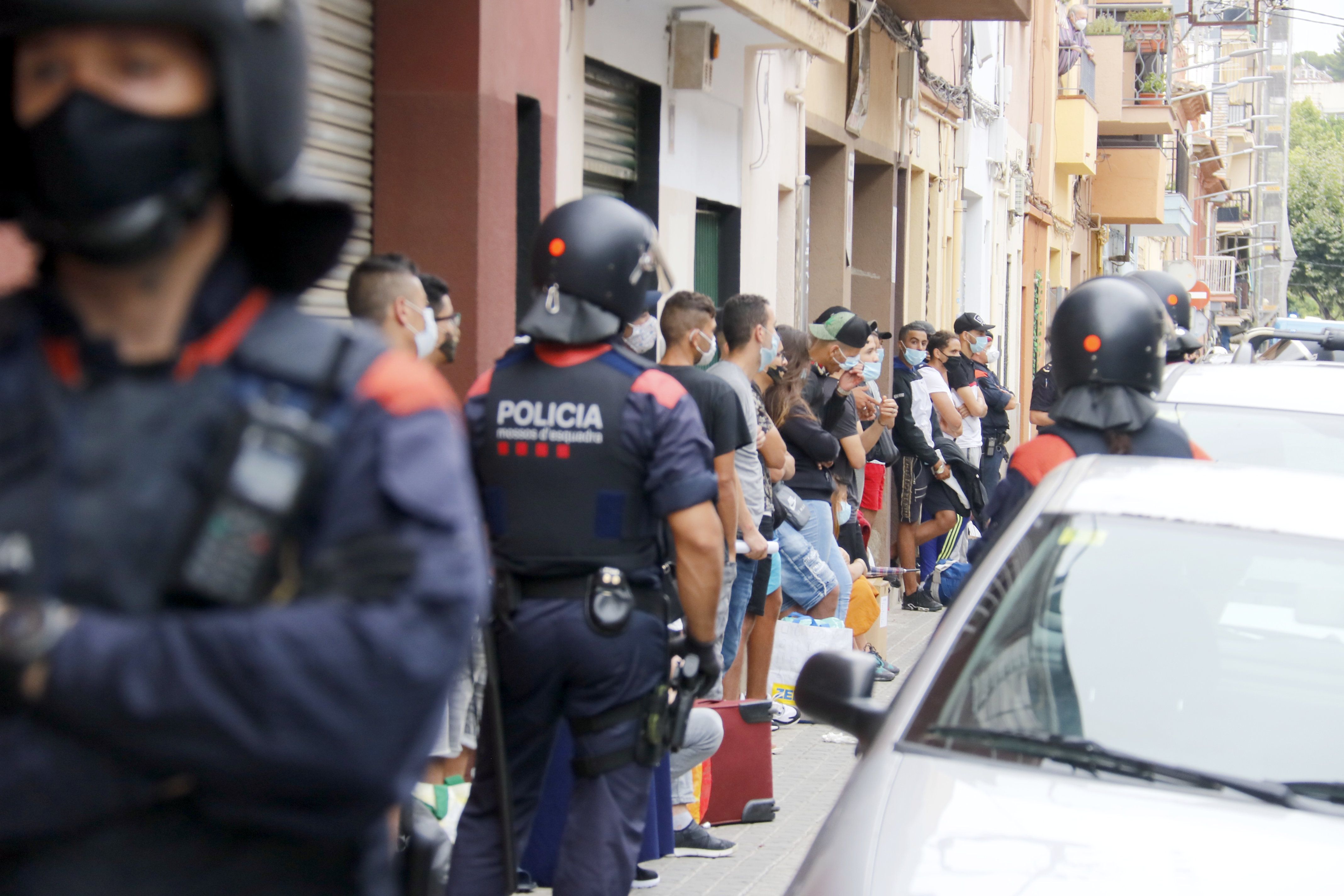 Los ocupas desalojados y la policía, durante el desahucio. Foto: ACN