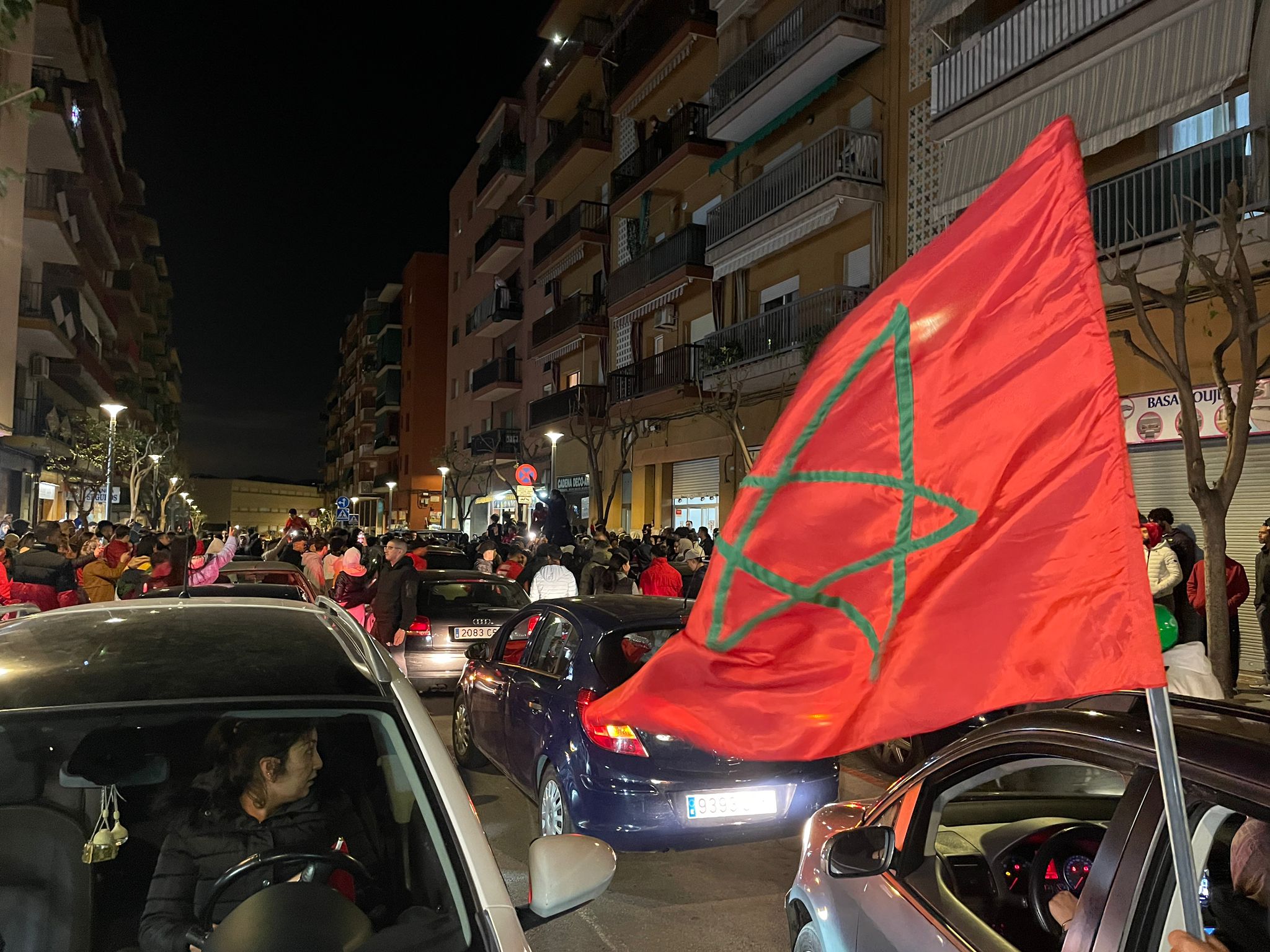 Joves fent onejar la bandera del Marroc al barri de Rocafonda