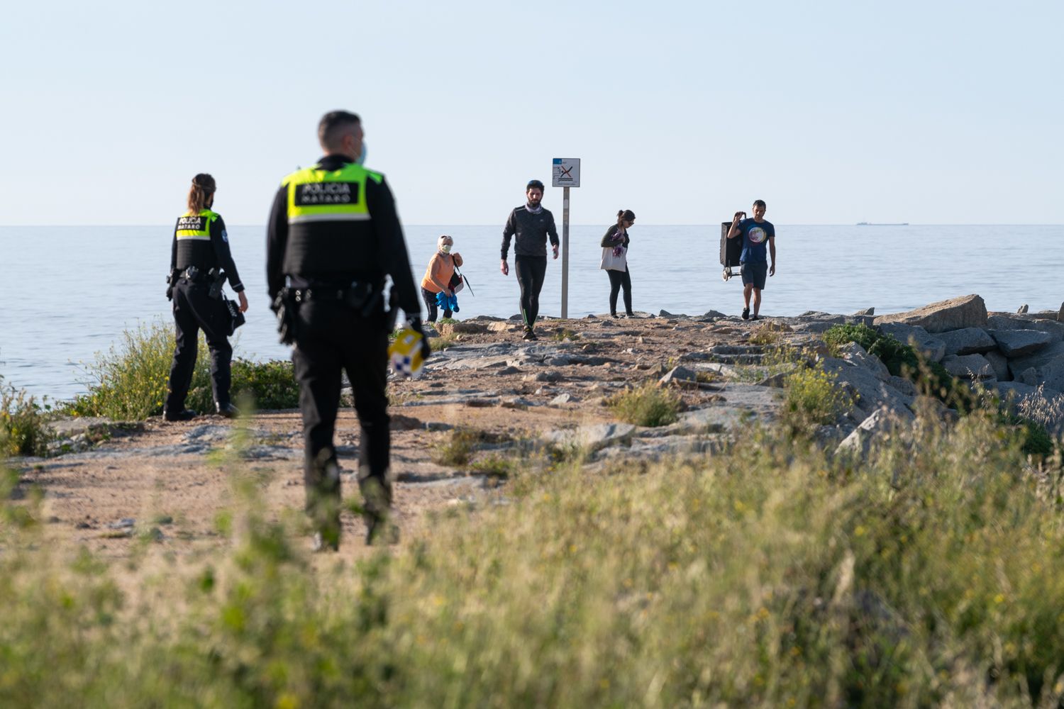 Policia Local fent fora a la gent de l'espigó, una de les accions que poden suposar multes